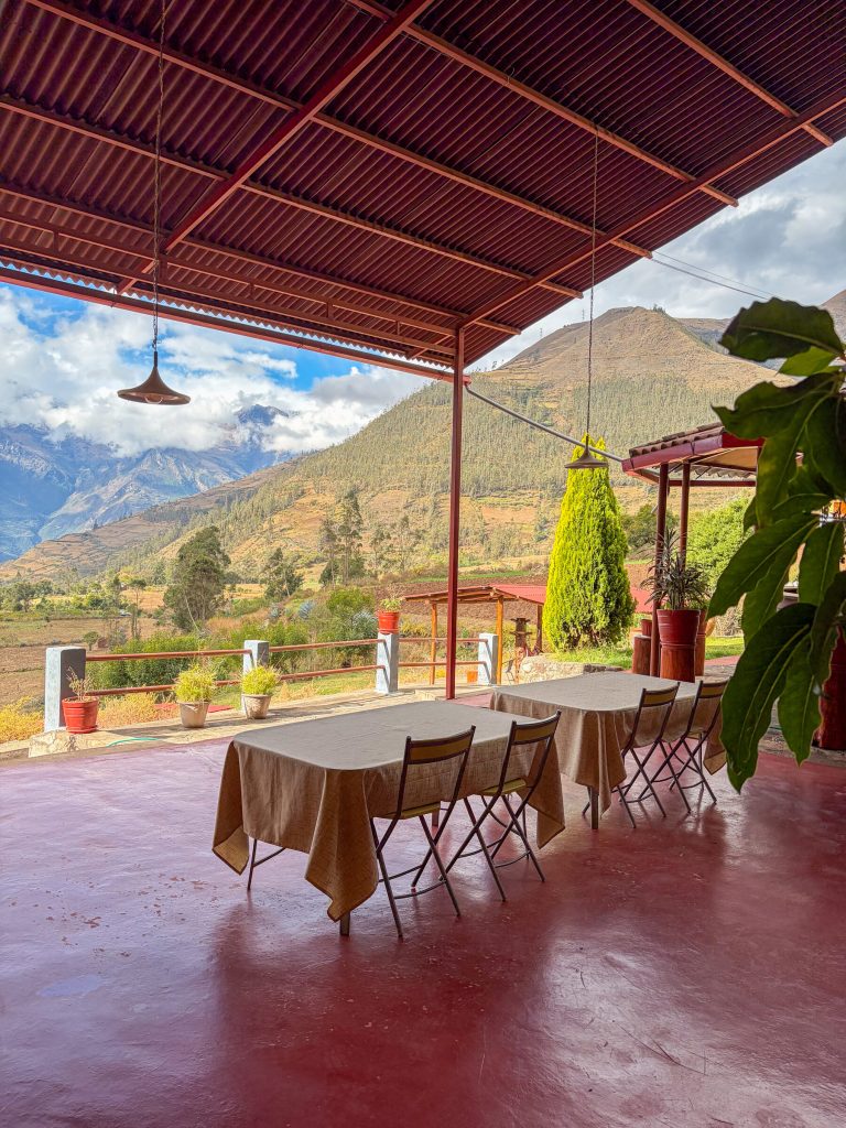 Terraza techada con mesas y vista al valle